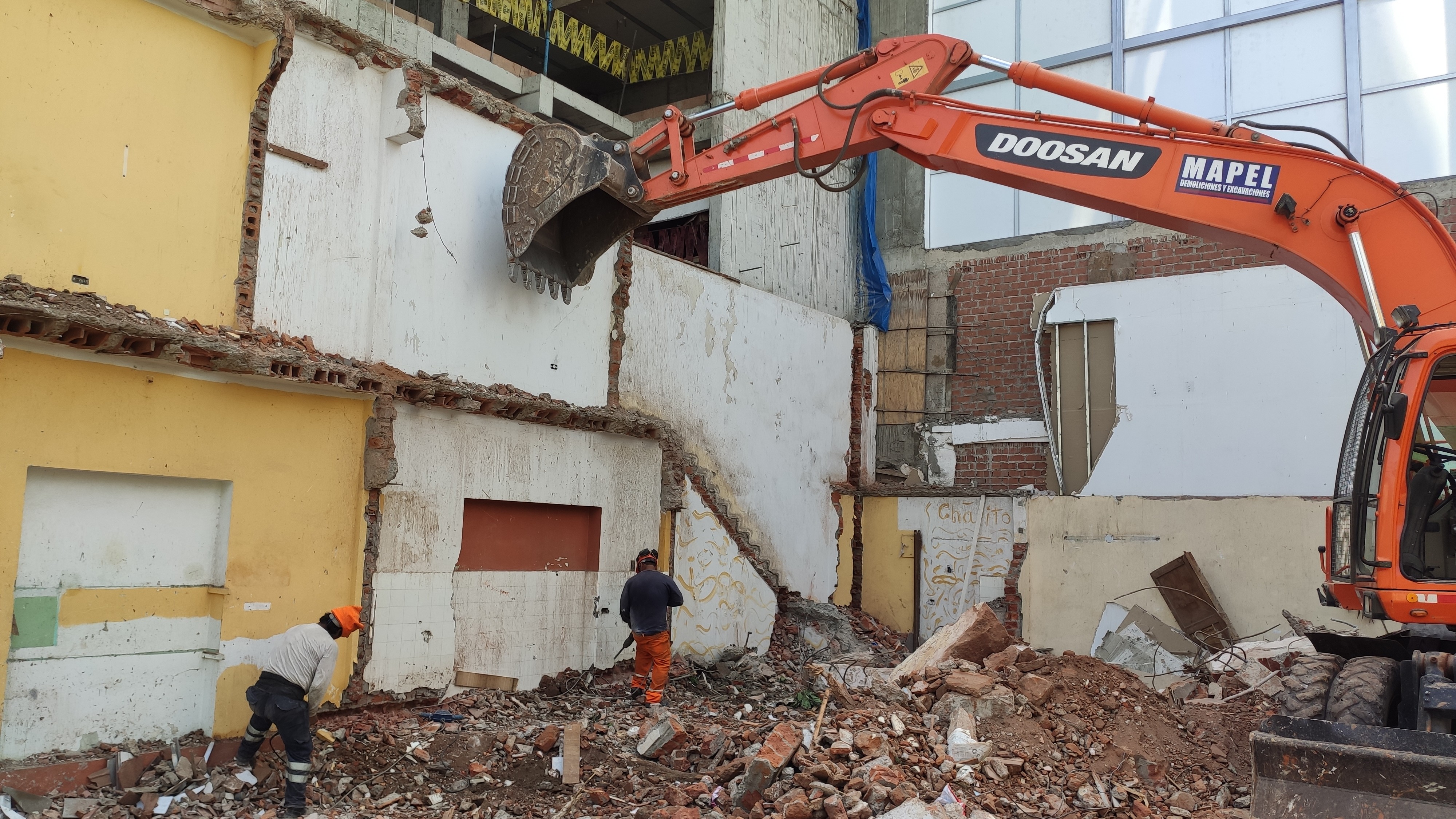 Obreros de Mapel demoliendo cimientos antiguos de ladrillo en obra de demolición en Lima