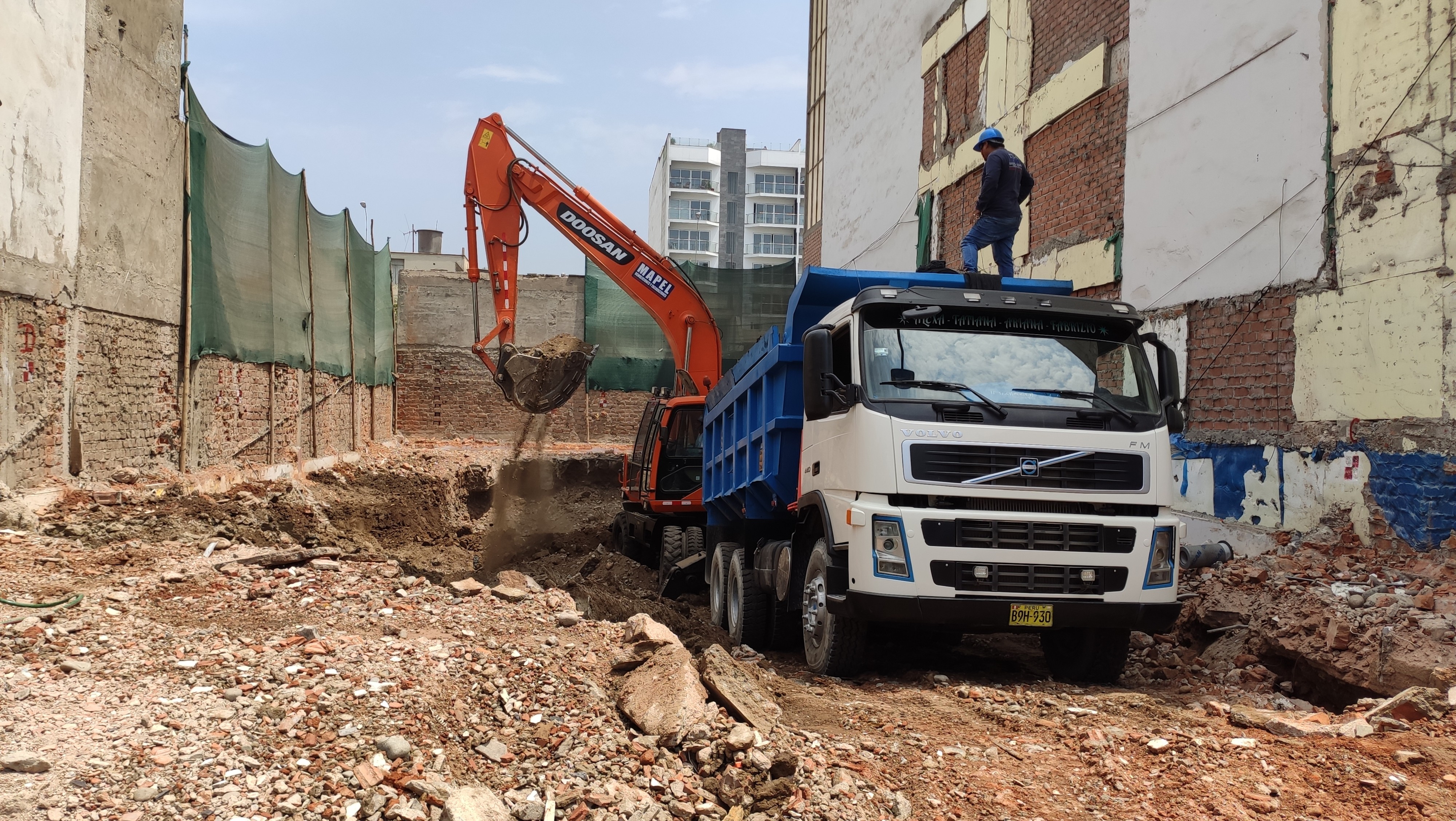 Excavadora y volquete de Mapel E.I.R.L. eliminando material en obra de excavación en Lima